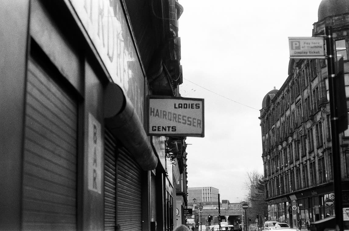 Hairdresser&rsquo;s sign on a shuttered street, 35mm