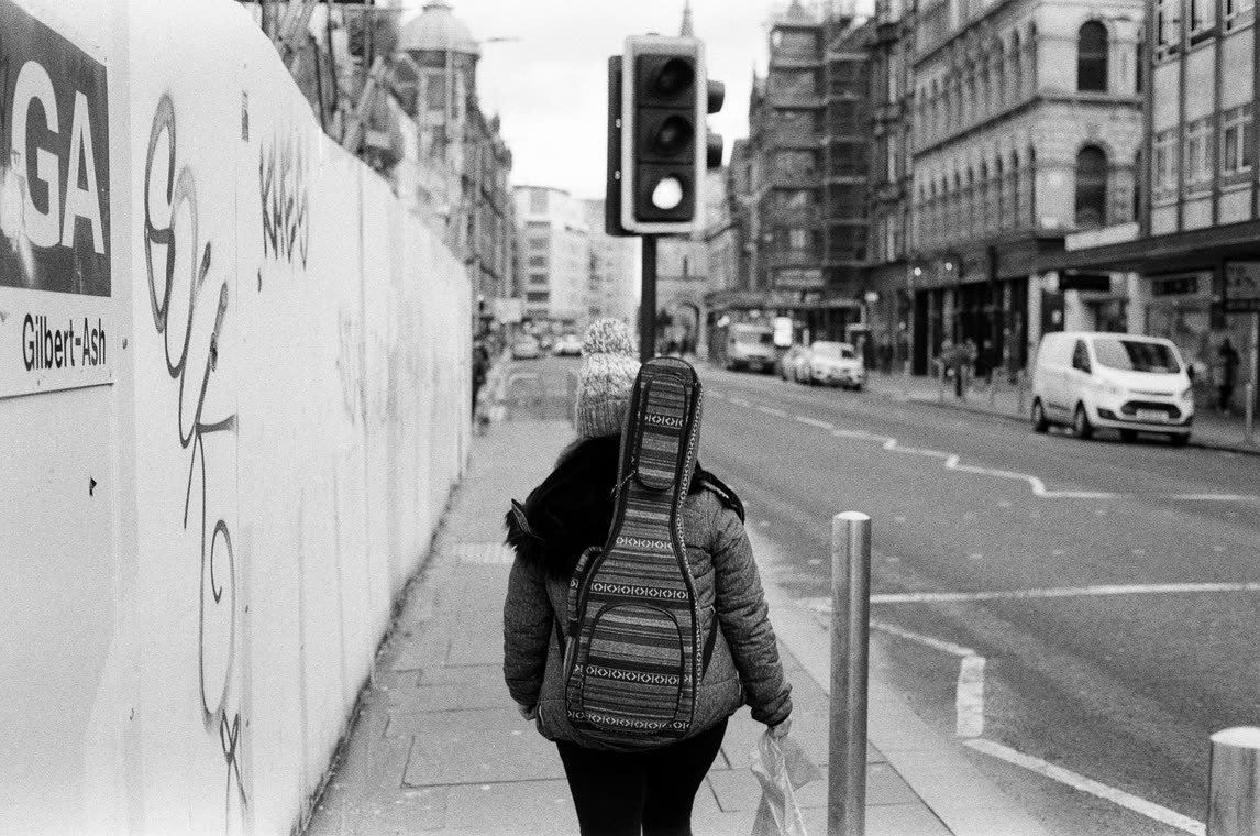 Waiting at the lights beside a graffitied hoarding, 35mm